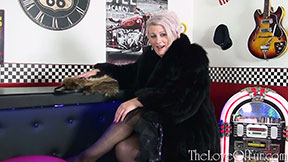 Mature Sally Taylor in black fur jacket stockings in diner